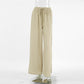 High-waisted wide-leg trousers in a breathable, slubbed oat-beige cotton fabric, featuring a drawstring waist and deep side slits for a flowing silhouette.