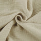 Close-up of Rhyzen wide-leg trousers fabric, showcasing the breathable, slubbed oat-beige cotton texture and flowing drape.