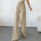 High-waisted, wide-leg trousers in textured oat-beige breathable cotton, featuring a drawstring waist and dramatic deep side slits up to the thigh.