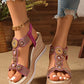 Women's rose gold embellished wedge sandals featuring circular rhinestone patterns and a woven espadrille sole, styled with distressed denim jeans.
