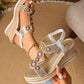 Embellished rose-gold and gold wedge sandals worn on a foot, showcasing circular rhinestone and bead details on the vamp strap and a woven espadrille-style wedge sole. Features an elasticated slingback strap and a 'FASHION' detail on the footbed.