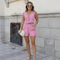 A woman models a rose pink cotton-linen blend sleeveless vest and high-waisted shorts set with V-neck, button front, drawstring waist, and patch pockets, styled for an outdoor casual look.