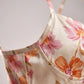 Close-up of Roselle floral satin slip dress bodice showing the structured corset-style stitching and vintage pink rose print.