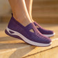 Deep Plum woven knit slip-on sneakers for women, featuring a triangular instep cutout and a crisp white sole, worn on sunlit stone steps.