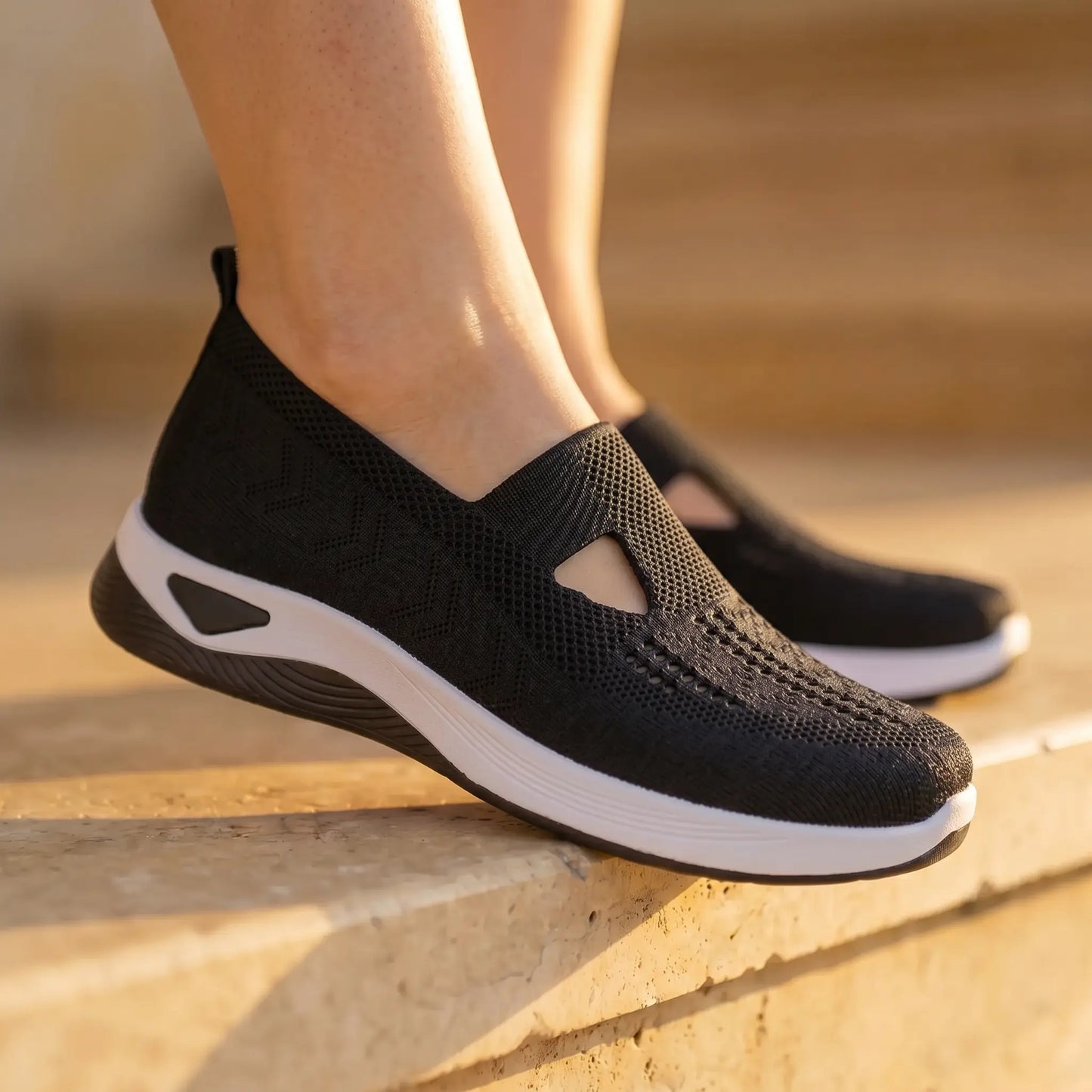 Ruxen Midnight Black woven slip-on sneakers worn on feet, detailing the breathable knit upper with triangular cutout, diamond perforations, and elegant white platform sole.