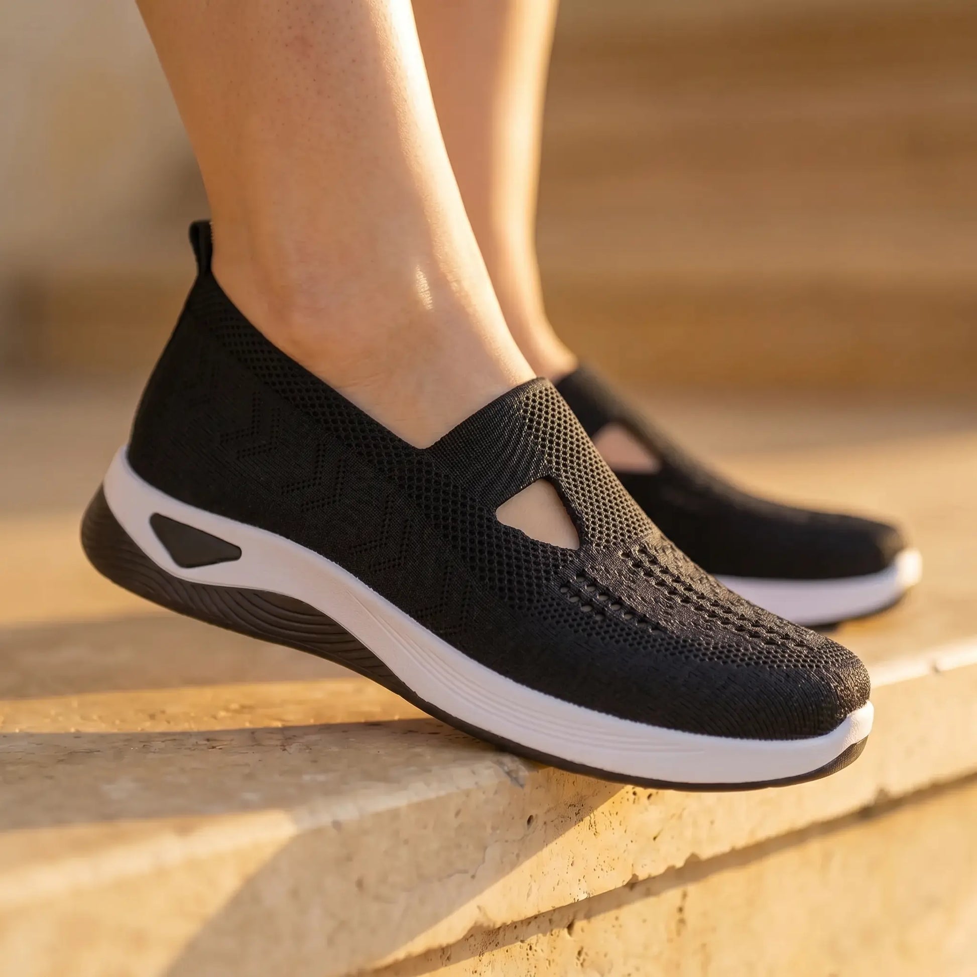 Ruxen Midnight Black woven slip-on sneakers worn on feet, detailing the breathable knit upper with triangular cutout, diamond perforations, and elegant white platform sole.