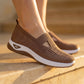 Person wearing Ruxen Rich Mocha woven knit slip-on sneakers with triangular cutout, diamond perforations, and white platform sole on stone steps.