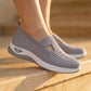 Ruxen Cloud Grey women's slip-on knit sneakers on feet, showcasing the breathable woven upper with triangular instep and white sole, outdoors on steps.
