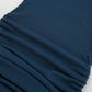Close-up view of a sapphire blue ribbed knit mini dress, showcasing its fine vertical ribbing texture and adjustable side ruching detail with drawstring ties.