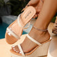 Woman's foot wearing Seraph platform espadrille wedge sandals with clear PVC straps and natural jute wrap. Seen in a lifestyle setting with a pool and greenery.