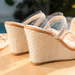 Close-up view of Seraph espadrille wedge sandals showcasing natural jute texture on the wedge and platform, with clear PVC straps and a light tan footbed trim.