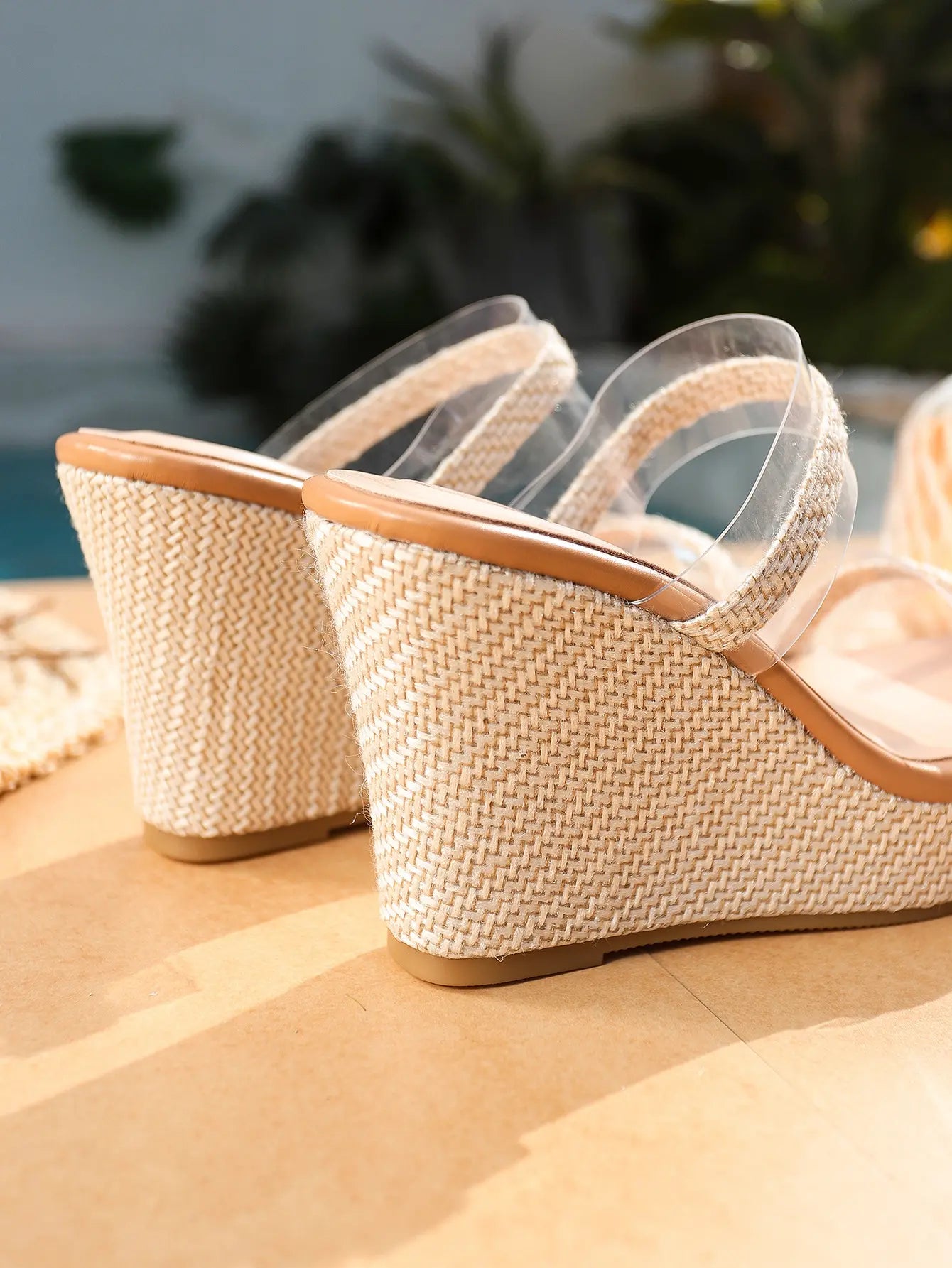 Close-up view of Seraph espadrille wedge sandals showcasing natural jute texture on the wedge and platform, with clear PVC straps and a light tan footbed trim.