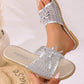 Elegant silver mesh bow slide sandals worn on a foot, showcasing the hexagonal mesh, metallic finish, delicate bow, and braided sole trim.