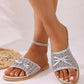 Elegant silver mesh bow slide sandals with a metallic finish, shown on a model's foot with clean, neutral-toned nails and a sparkly anklet.