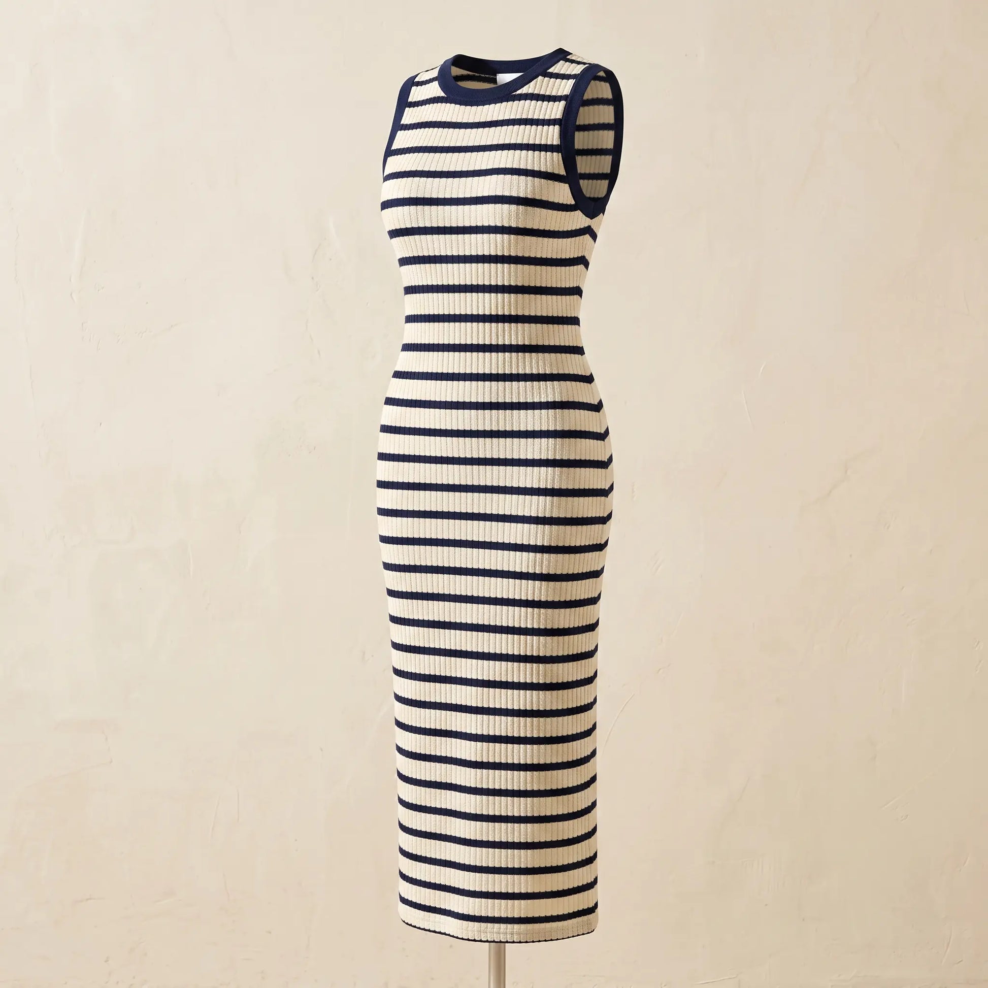 Sleeveless ribbed knit maxi dress with cream and navy horizontal stripes, featuring a classic crew neckline and solid armhole binding, on a mannequin.
