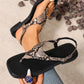 Bohemian snake print flat sandals with square toe and adjustable ankle strap, styled on a model's feet with denim. Elegant summer footwear with a distinctive print.