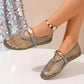 Stone Grey Solarae mesh flat sandals with a patent trim and decorative oval buckle strap, shown on a foot with a beaded anklet. Features a breathable design and round toe.