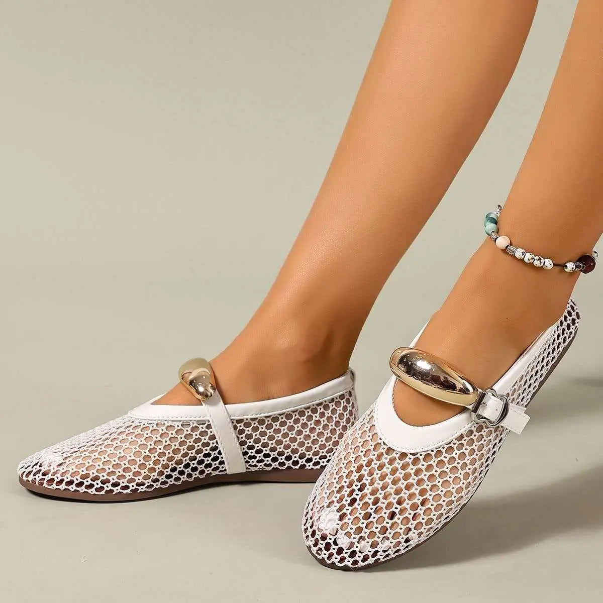 Women's Solarae white mesh flat sandals with decorative gold buckle strap and patent trim, shown on a model's feet with an anklet.