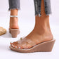 Women's Sorani clear strap wedge sandals with a gold pearl embellishment on a model's foot against a white background.