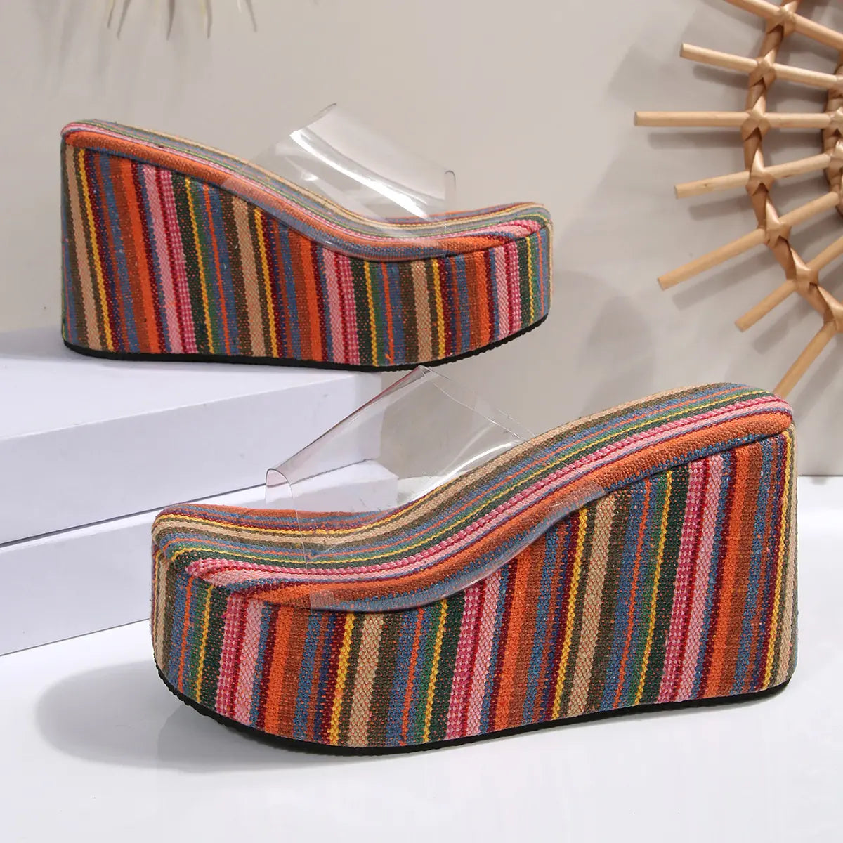 Bohemian stripe platform wedge slide sandals with a clear PVC upper strap, showcasing vibrant multi-colored vertical stripes on the substantial wedge.