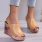 Tan peep-toe wedge mule sandals with a textured rose gold and brown patterned wedge heel, worn with light blue distressed jeans.