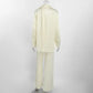 Back view of the Tarkem ivory buttercream crinkle-pleat two-piece set, highlighting the relaxed shirt and wide-leg trousers.