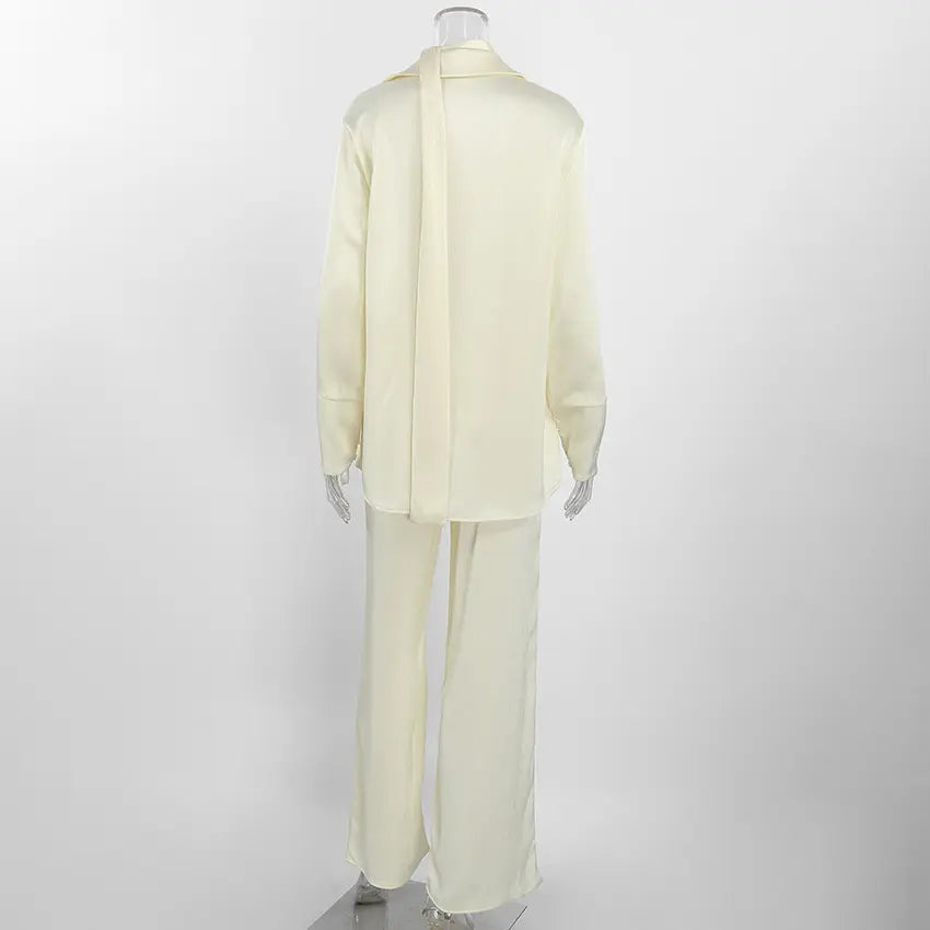 Back view of the Tarkem ivory buttercream crinkle-pleat two-piece set, highlighting the relaxed shirt and wide-leg trousers.
