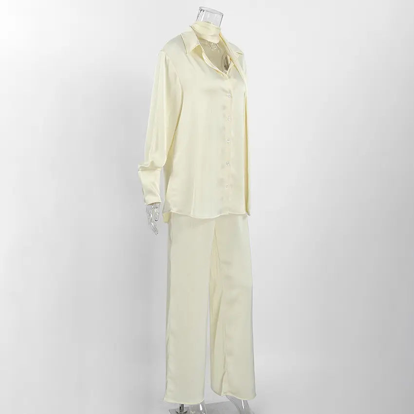 Side view of Tarkem ivory buttercream crinkle pleat two-piece set on a mannequin, with a long-sleeved collared shirt and wide-leg trousers.