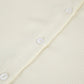 Close-up of the Tarkem ivory buttercream two-piece set, highlighting the exquisite micro-pleated fabric texture and tonal button placket.