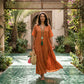 Model wearing a terracotta rust crinkled tiered maxi dress with V-neck and short sleeves, walking in a beautiful courtyard.