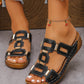 Black Torquin platform slide sandals featuring interlocking textured straps and gold-tone hardware, worn on a woman's feet with white-painted toenails and a cherry anklet.