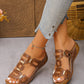 Women's brown slide platform sandals featuring interlocking textured straps with gold-tone hardware, detailed white contrast stitching, and a contoured footbed, worn by a model with cropped jeans.