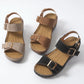 Three pairs of Torvin wedge sandals shown in black, tan, and brown faux suede with gold buckle details on a white background.