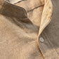 Close-up of a lime green mandarin collar linen shirt showing the textured fabric weave and white button detail.