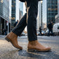 Vantor Classic Chelsea Boots in burnished tan microfiber leather worn on a city street, side view showing the elastic gore and rubber sole.