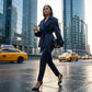 Varelle structured belted short trench coat in navy blue worn by a woman in a city setting — side view showing the cinched waist.