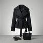 Varelle structured belted short trench coat in black cotton blend — front view styled with leather gloves and tote bag.