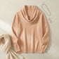 Vellura soft cowl neck knit sweater in apricot beige, styled flat lay showing the elegant draped neckline and ribbed cuffs.
