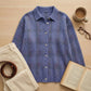 Vellura women's soft knit plaid shirt in slate blue with a brushed texture, styled in a flat-lay with corduroy pants and a book.