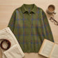 Vellura women's soft knit plaid shirt in olive green, displayed in a cozy lifestyle flat-lay with a book, glasses, and corduroy trousers.