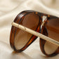 VELORA retro aviator sunglasses detail showing tortoise shell acetate rim and reinforced gold-tone metal hinge connection.