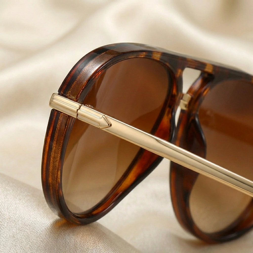 VELORA retro aviator sunglasses detail showing tortoise shell acetate rim and reinforced gold-tone metal hinge connection.