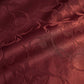 Close-up view of Veloura burgundy jacquard fabric texture showing the raised floral relief pattern and subtle sheen.