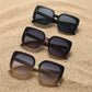 Vesryn oversized square sunglasses collection showcasing three pairs in black, brown, and cream with gradient lenses and floral-inspired gold accent details.