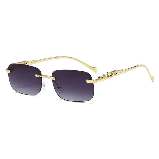 Vexiom Statement Leopard Sunglasses in polished gold-tone metal, featuring rimless square gradient charcoal grey lenses and detailed sculpted leopard head temple embellishments.