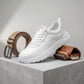 Vexor men's shock-absorbing urban sneaker in white microfiber leather, side profile view styled with a leather belt and shoe care kit.
