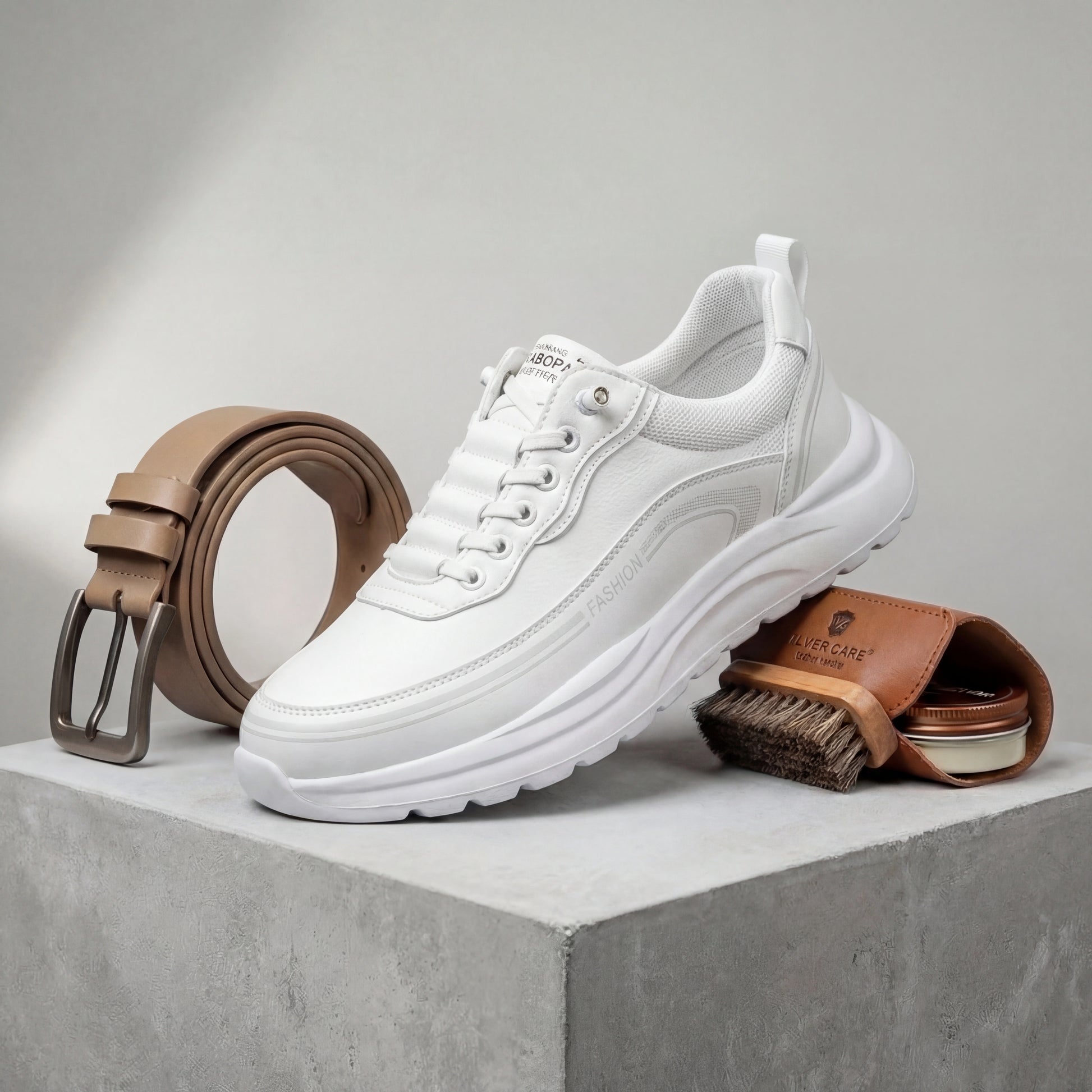 Vexor men's shock-absorbing urban sneaker in white microfiber leather, side profile view styled with a leather belt and shoe care kit.