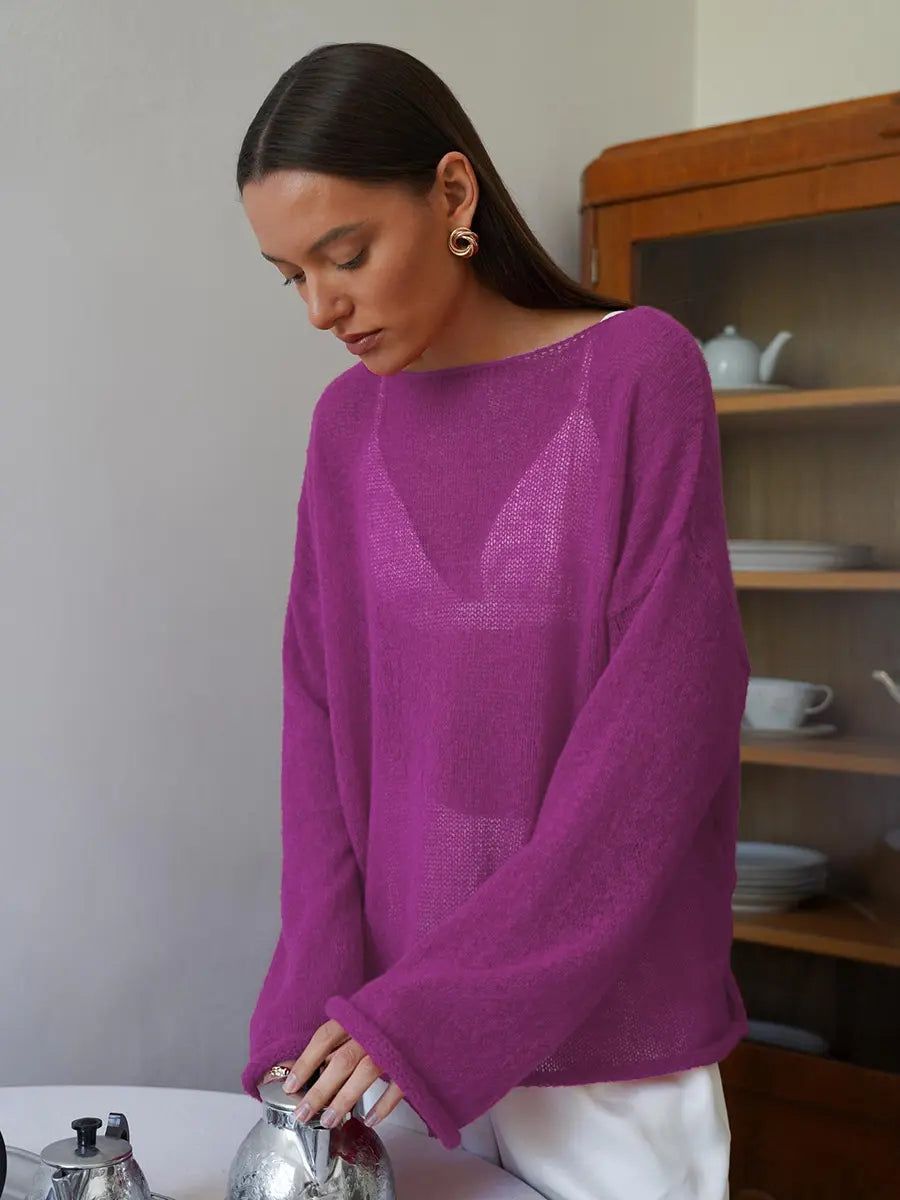 Female model wearing a vibrant rose sheer bell sleeve knit sweater with a boat neck, styled over a white bralette, in an indoor setting.