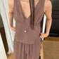 A woman models a muted taupe sleeveless V-neck flowy resort set featuring a gathered bust top and wide-leg elastic drawstring trousers.