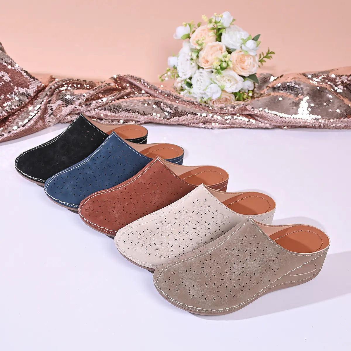 Vylos comfortable wedge mules displayed in multiple colors: black, blue, brown, cream, and taupe, featuring perforated floral uppers and white stitching.
